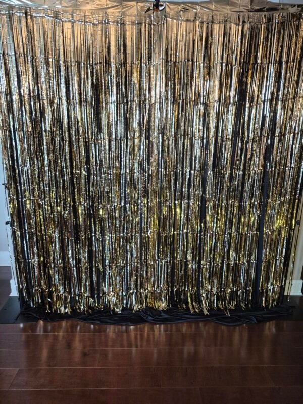 Gold foil fringe backdrop with shimmering gold fringe for parties and events.
